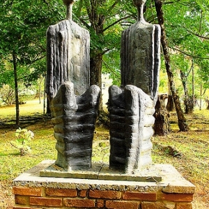 Escultura "Casal II" de Felícia Leirner. Feita em bronze, a escultura se assemelha a duas pessoas sentadas lado a lado.