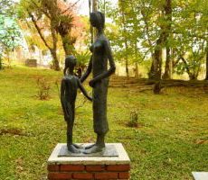 Escultura "Mãe e Filha" de Felícia Leirner. A escultura é feita em bronze e aparentemente representa uma filha pequena de frente para sua mãe, alta.