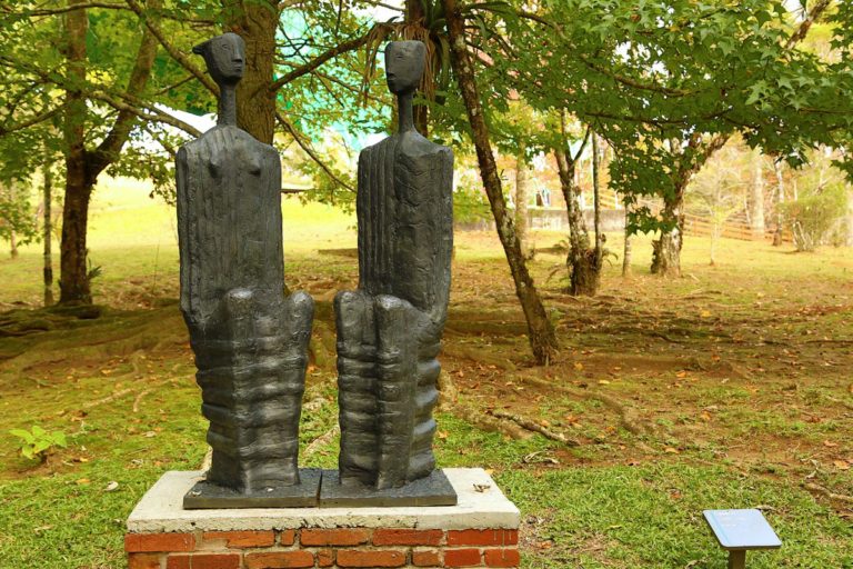 Escultura "Casal II" de Felícia Leirner. Feita em bronze, a escultura se assemelha a duas pessoas sentadas lado a lado.