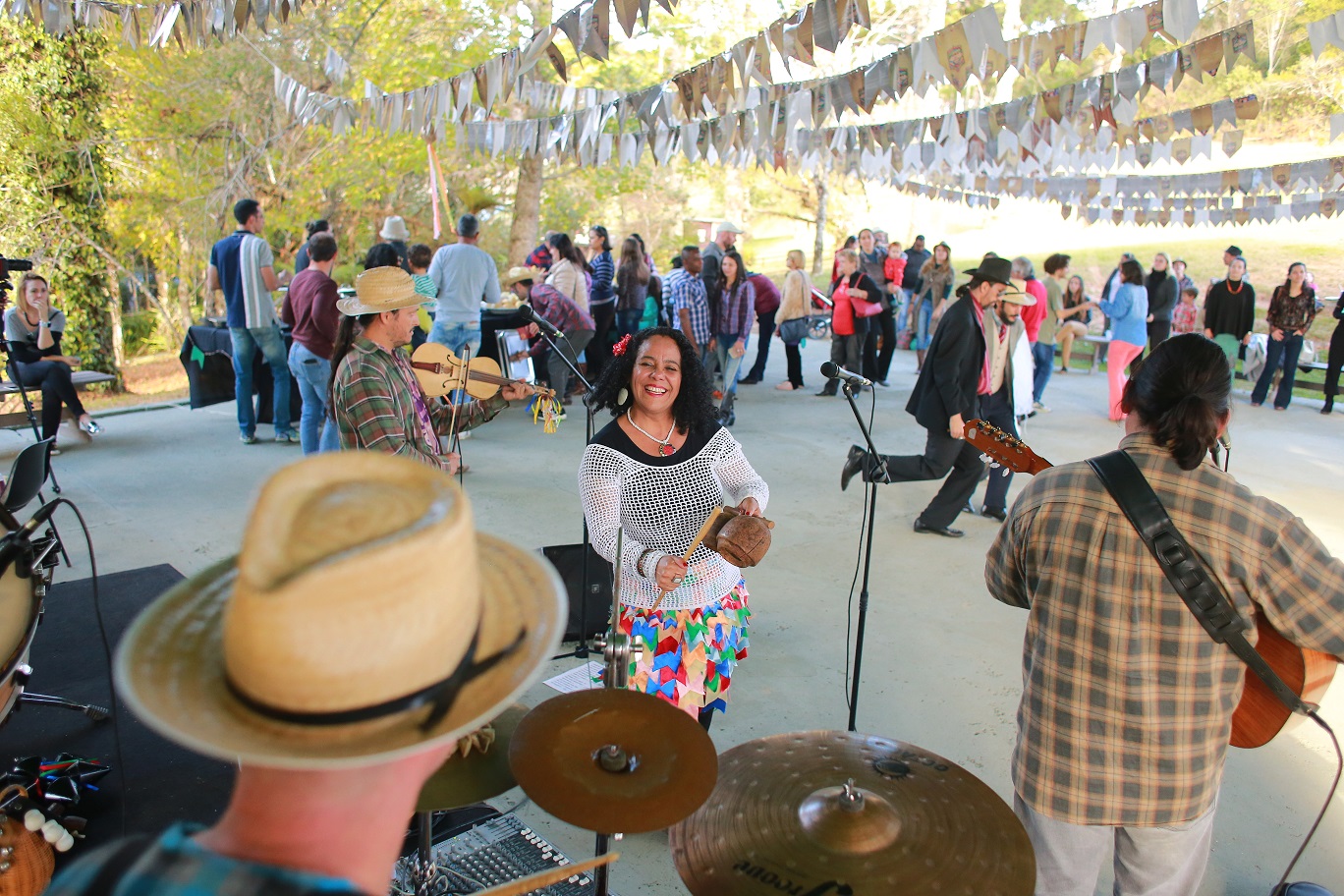 Festa junina na concha do Museu. Pessoas dançam enquanto uma banda está tocando.