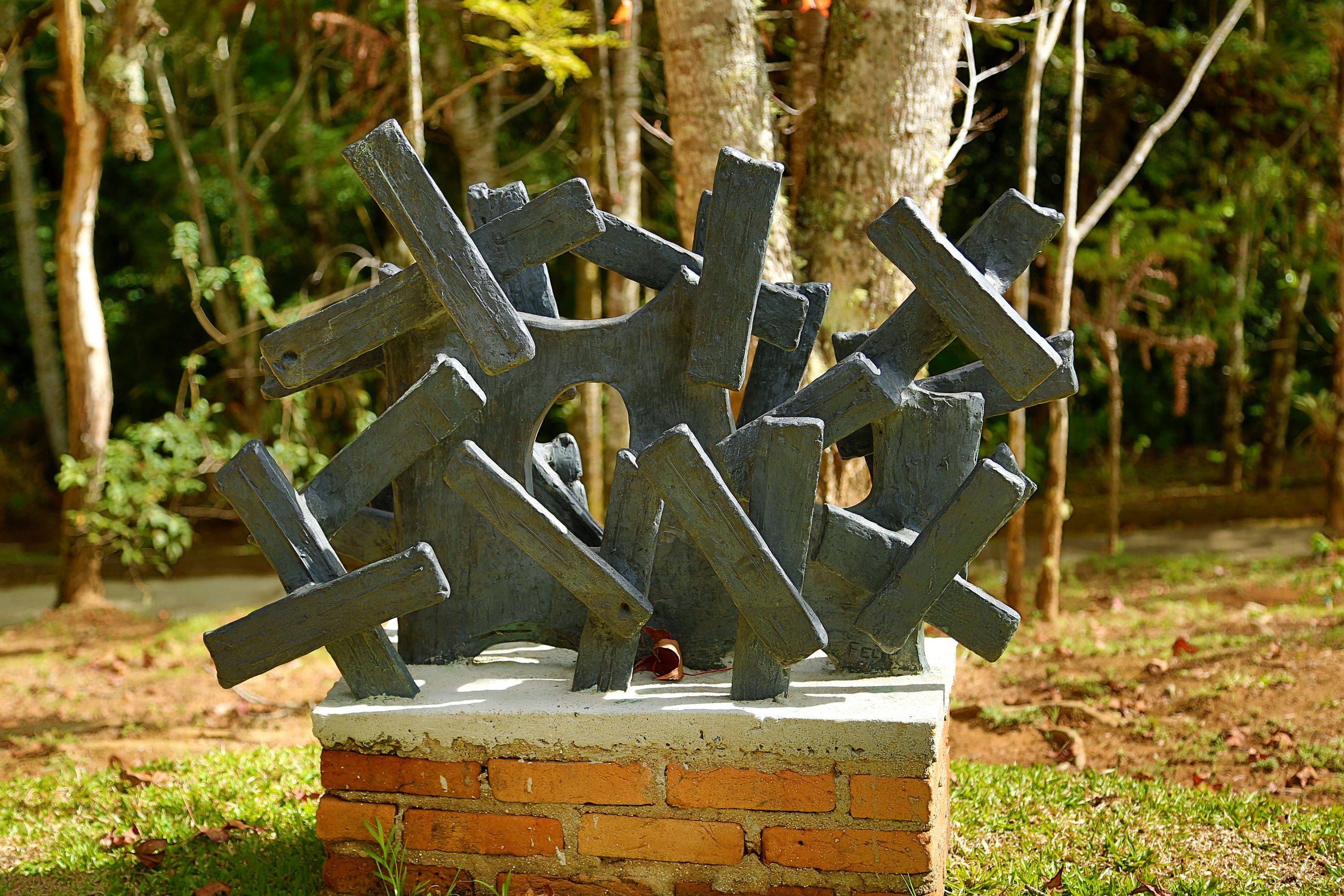 Escultura em formas de cruzes feita em bronze e posicionada ao ar livre.